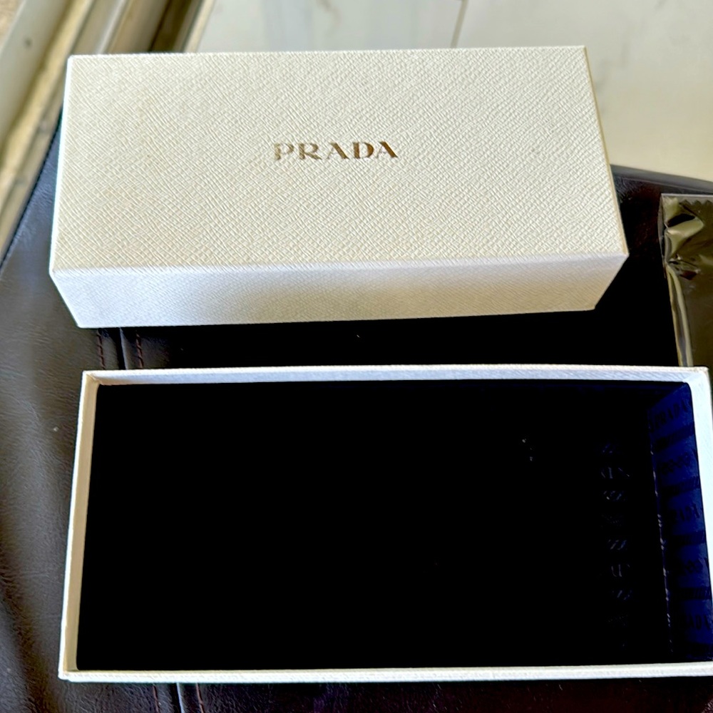Prada empty box includes card and cleaning wipe for sunglasses